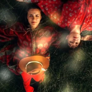 Agnieszka Abraham i Iza Damek w czerwonych strojach, leżące na trawie