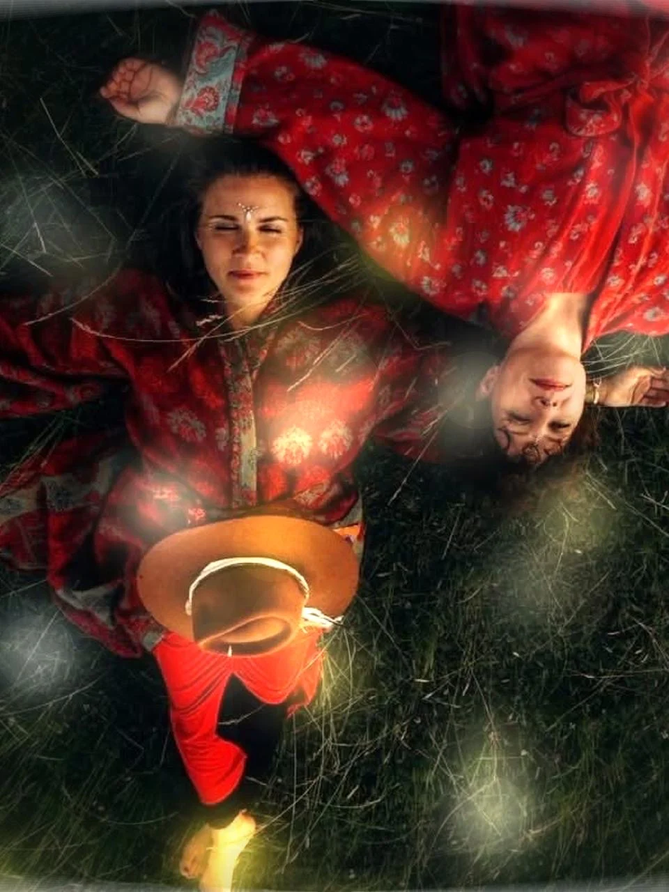 Agnieszka Abraham i Iza Damek w czerwonych strojach, leżące na trawie